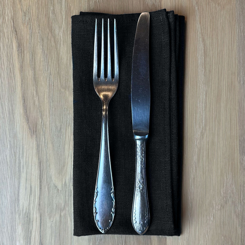 Fork-and-knife-on-black-linen-napkin