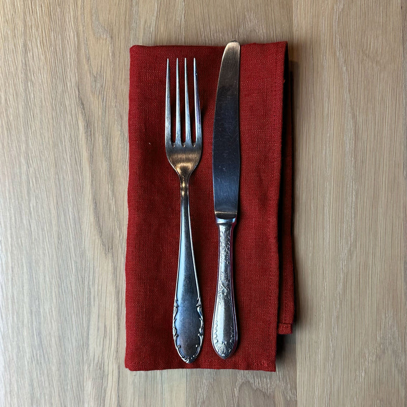 Fork-and-knife-on-carmine-red-linen-napkin