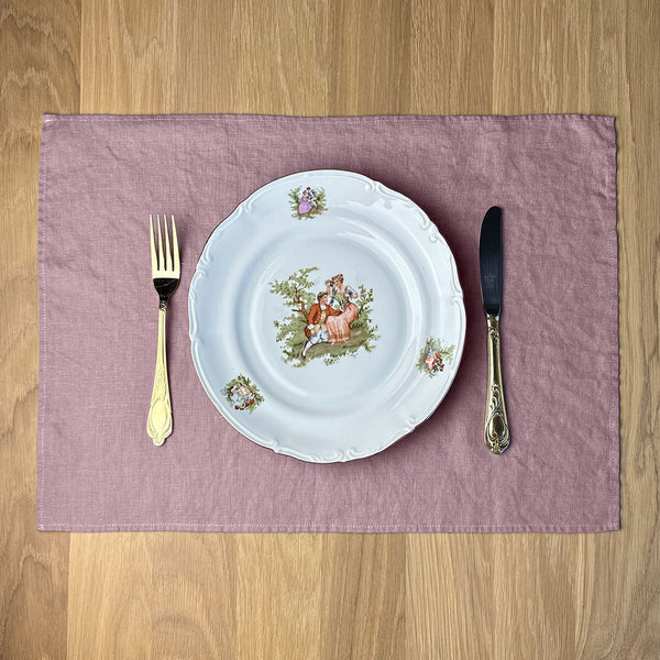 Plate-with-Man-and-woman_-fork-and-knife-on-desert-rose-linen-placemat-on-wooden-table