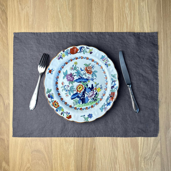 Plate-with-flowers_-knife-and-fork-on-anthracite-gray-linen-placemat-on-wooden-table