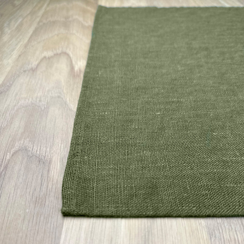 Corner-of-Olive-green-linen-placemat-on-wooden-table