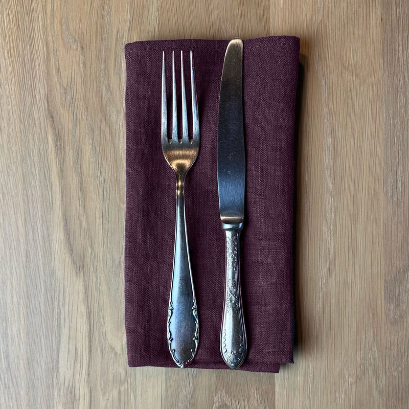 Fork-and-knife-on-aubergine-linen-napkin