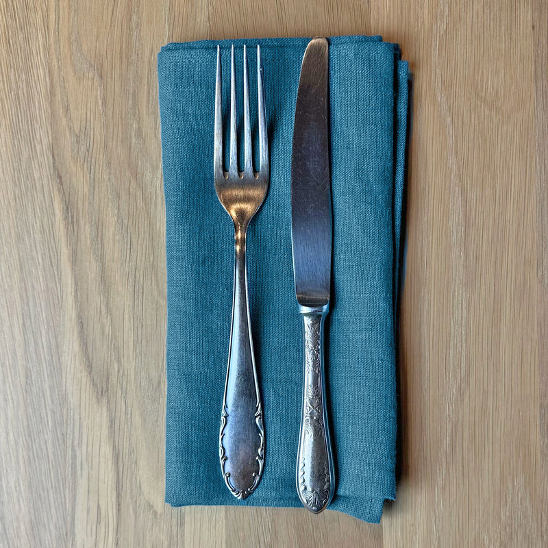 Fork-and-knife-on-petrol-blue-linen-napkin