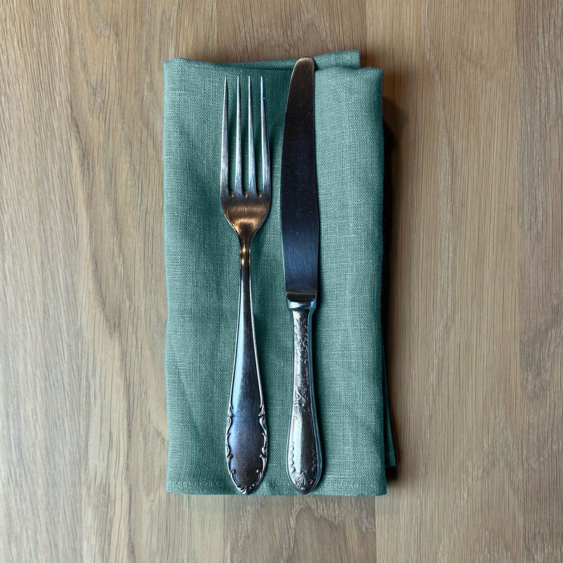 Fork-and-knife-on-turquoise-linen-napkin