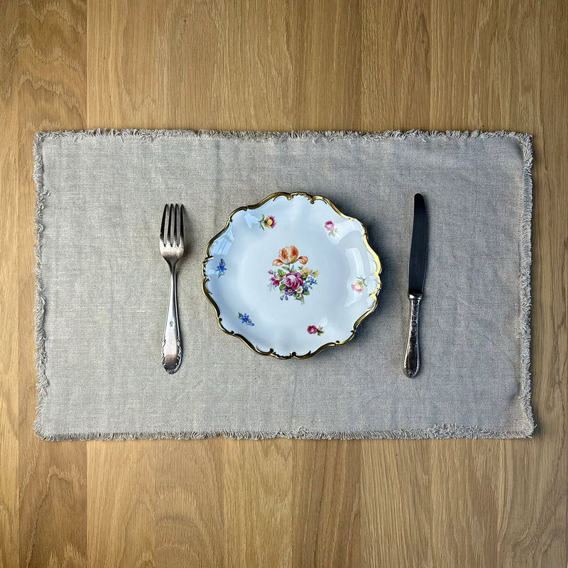 Fork spoon and plate on Linen placemat on wooden table