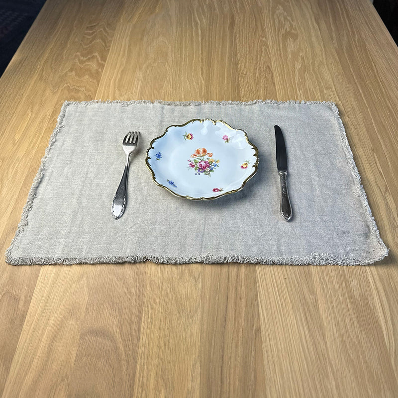 Fork spoon and plates on Linen placemat on wooden table