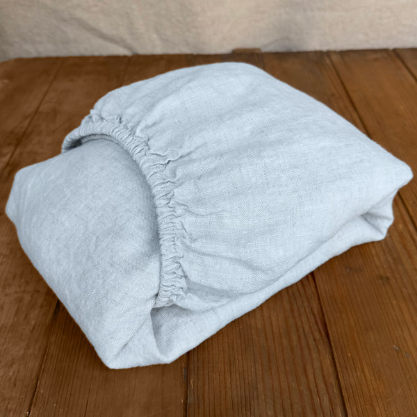 Linen fitted sheet ice blue on wooden box
