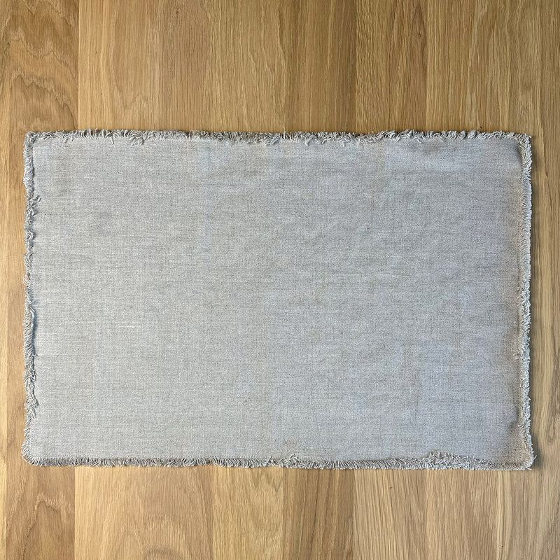 Natural gray Linen placemat with fringe on wooden table