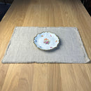 Nice plate on Natural gray Linen placemat with fringe on wooden table