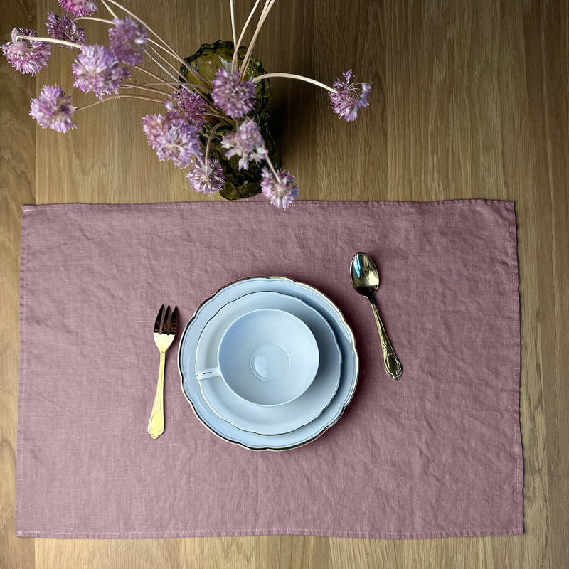 Violet-Flowers_-White-cup-fork-spoon-and-plates-on-desert-rose-Linen-placemat-on-wooden-table
