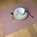 White-cup-fork-spoon-and-plates-on-desert-rose-Linen-placemat-on-wooden-table