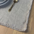 White Plate with flowers and golden edges on natural gray Linen placemat on wooden table