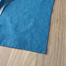 Plate-with-flowers_-knife-and-fork-on-petrol-linen-placemat-on-wooden-table