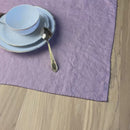 Plate-with-Man-and-woman,-fork-and-knife-on-desert-rose-linen-placemat-on-wooden-table